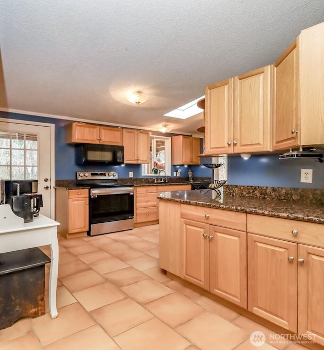 kitchen featuring stainless steel electric range, a skylight, dark stone counters, and light brown cabinets