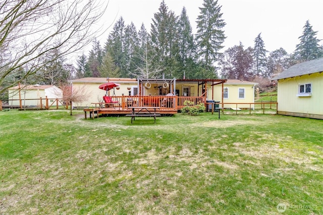 rear view of property with a wooden deck and a lawn