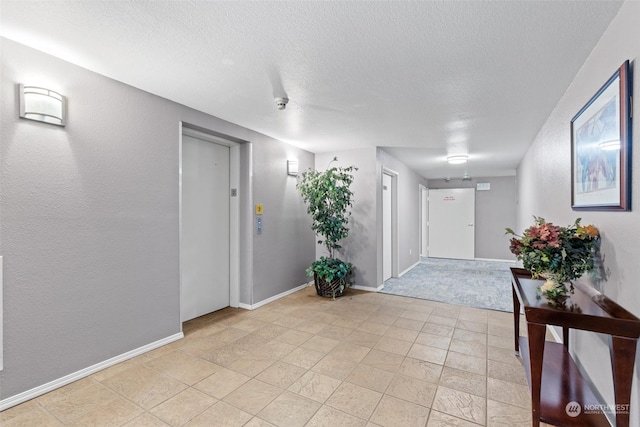 entrance foyer featuring elevator and a textured ceiling