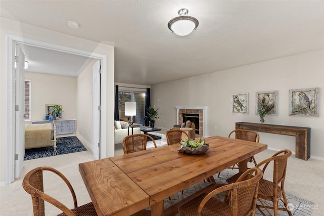 dining room with a fireplace and light carpet