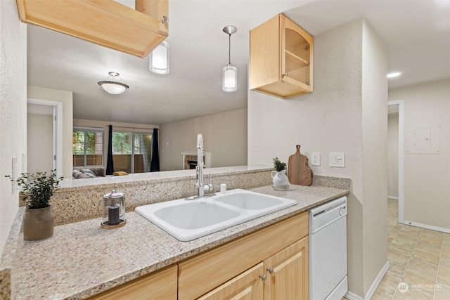 kitchen featuring light brown cabinetry, decorative light fixtures, sink, white dishwasher, and light stone countertops