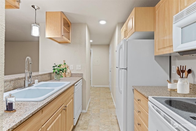 kitchen with decorative light fixtures, sink, light stone countertops, light brown cabinets, and white appliances