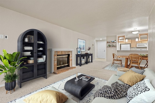 living room featuring light carpet, a fireplace, and a textured ceiling