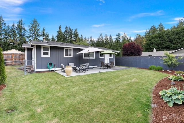 rear view of house with a yard and a patio