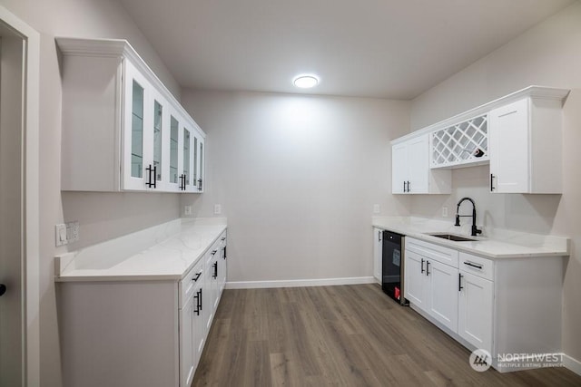 kitchen with light stone countertops, sink, and white cabinets