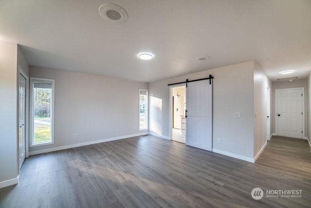 spare room with a barn door and hardwood / wood-style floors