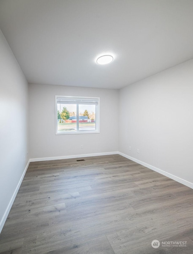 unfurnished room with hardwood / wood-style flooring