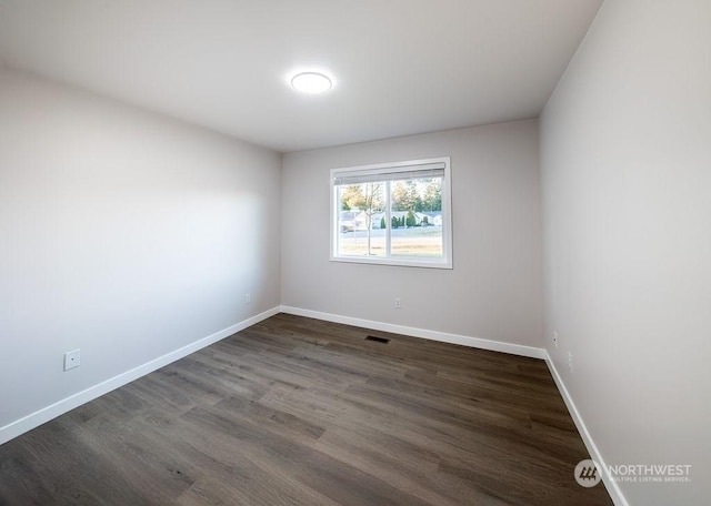 spare room featuring dark wood-type flooring