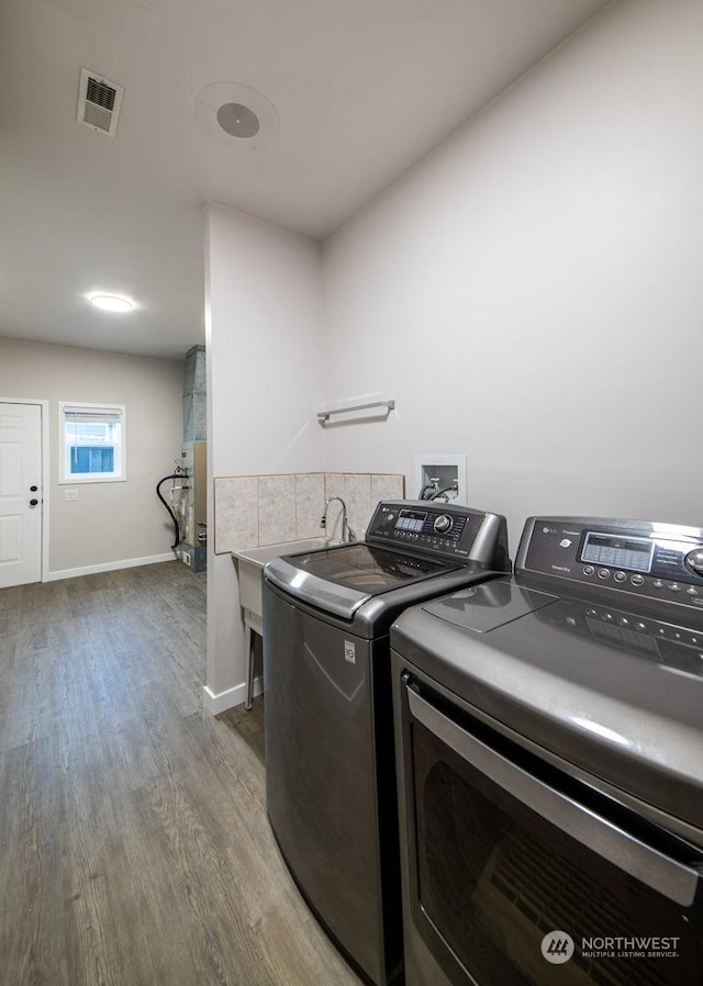 washroom featuring washing machine and clothes dryer and light wood-type flooring