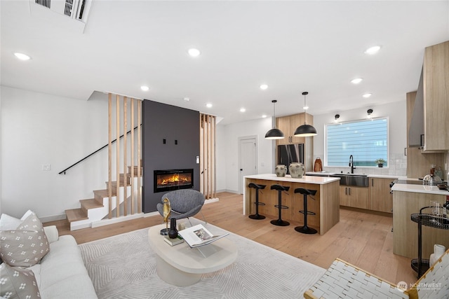 living room with sink and light hardwood / wood-style floors