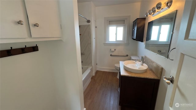 full bathroom featuring vanity, hardwood / wood-style floors, shower / bathtub combination, and toilet