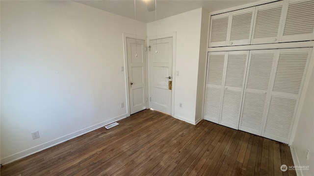 unfurnished bedroom featuring dark hardwood / wood-style floors and a closet