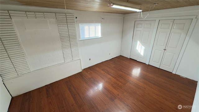 unfurnished bedroom featuring dark hardwood / wood-style flooring and wood ceiling