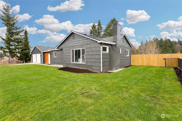 back of house featuring a yard and a garage