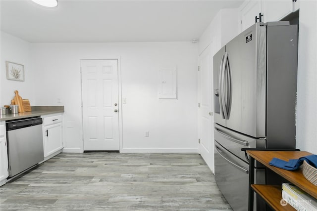 kitchen with stainless steel appliances, white cabinetry, electric panel, and light hardwood / wood-style floors