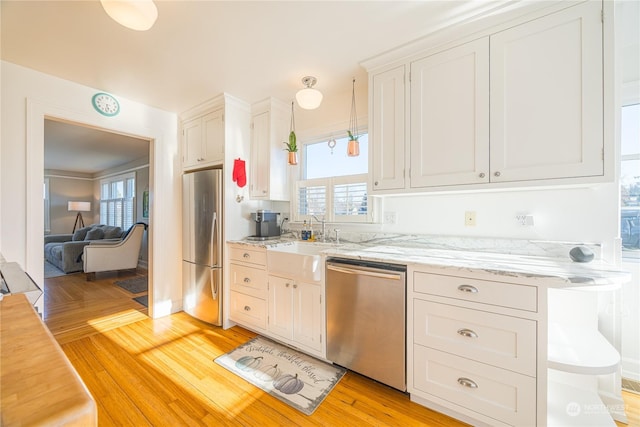 kitchen with white cabinetry, sink, light hardwood / wood-style flooring, and appliances with stainless steel finishes