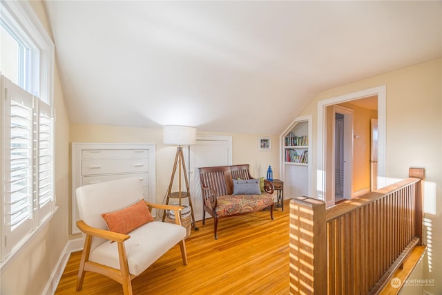 living area featuring lofted ceiling and hardwood / wood-style floors