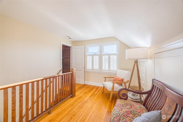 living area featuring lofted ceiling and light hardwood / wood-style flooring