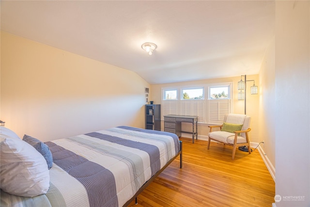 bedroom with lofted ceiling and light hardwood / wood-style floors