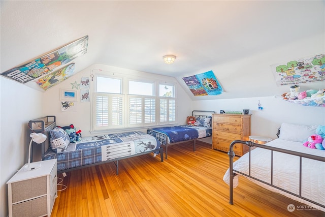 bedroom featuring hardwood / wood-style flooring and lofted ceiling