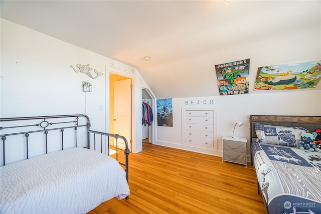 bedroom with lofted ceiling and light hardwood / wood-style floors