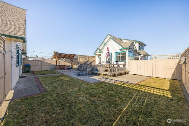 view of yard featuring a wooden deck and a patio