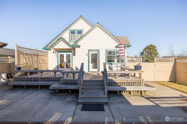 back of property with a wooden deck and a patio area