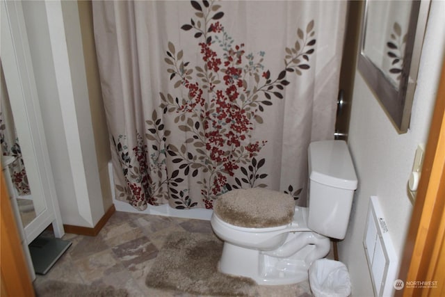 bathroom featuring a shower with shower curtain and toilet