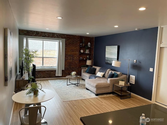 living room with brick wall and wood-type flooring