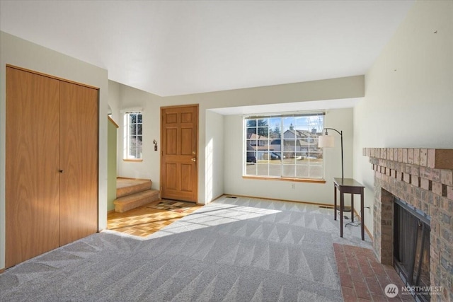 unfurnished living room featuring a fireplace and light colored carpet