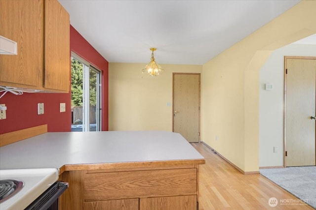 kitchen featuring light hardwood / wood-style flooring, kitchen peninsula, a chandelier, and decorative light fixtures