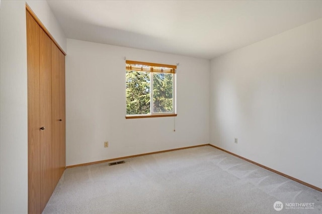 unfurnished bedroom with a closet and light carpet