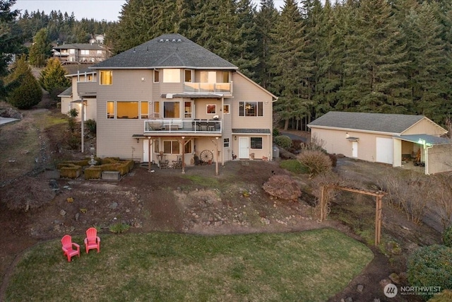 rear view of property featuring an outbuilding and a balcony