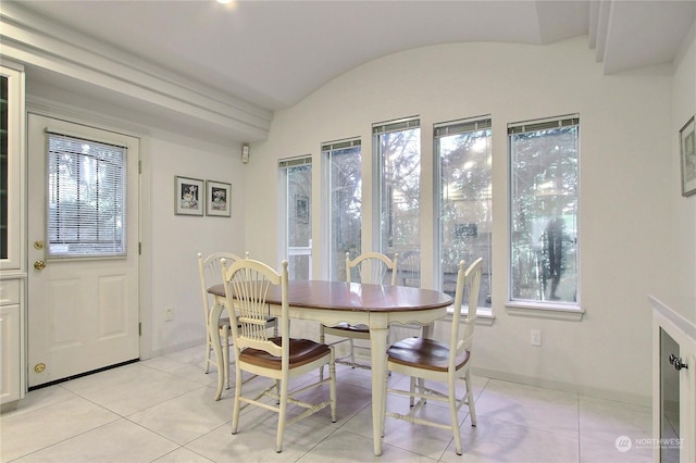 dining area featuring light tile patterned floors, vaulted ceiling, and a healthy amount of sunlight