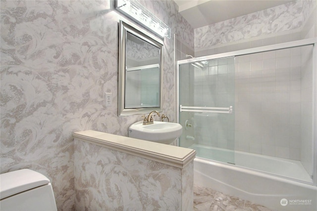 full bathroom featuring sink, enclosed tub / shower combo, and toilet