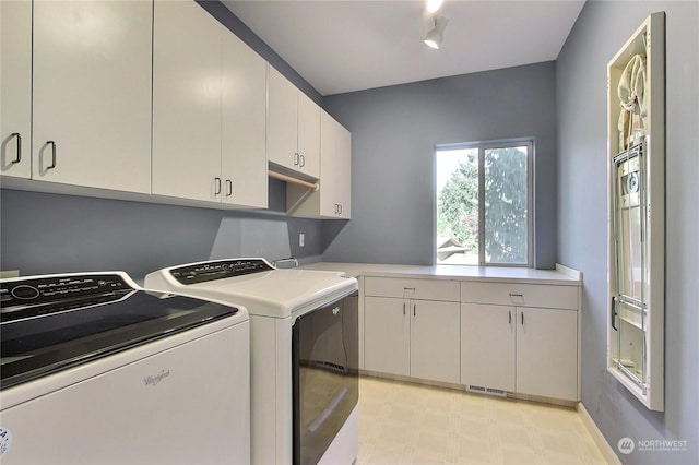 washroom with cabinets, track lighting, and washing machine and dryer