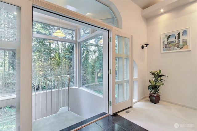 doorway to outside with dark tile patterned flooring