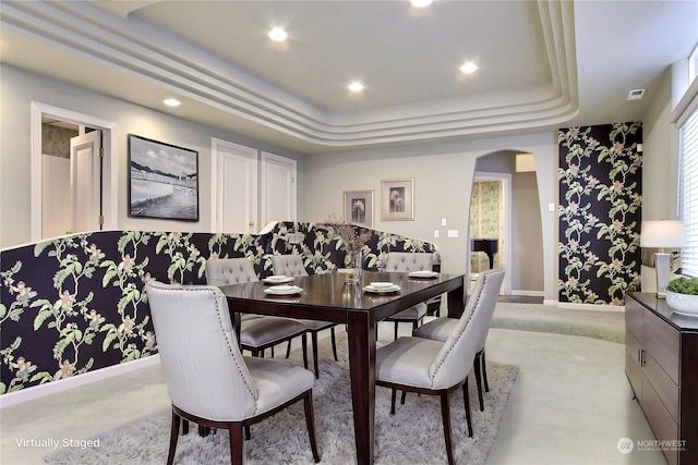 dining space with a raised ceiling