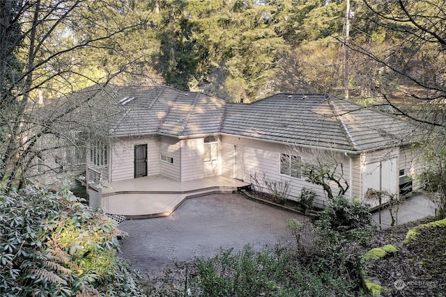 view of front of property featuring a wooden deck and a patio area