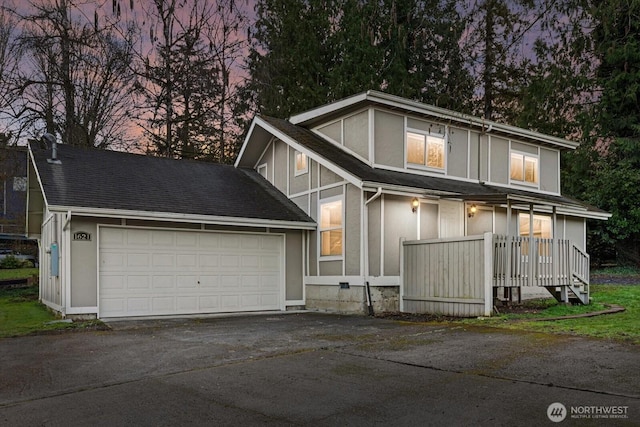 view of front of property featuring aphalt driveway, an attached garage, a shingled roof, and stucco siding