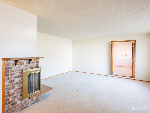 unfurnished living room with carpet flooring, a brick fireplace, and a textured ceiling