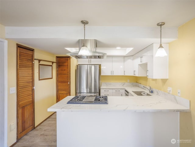 kitchen featuring white cabinetry, appliances with stainless steel finishes, decorative light fixtures, and kitchen peninsula