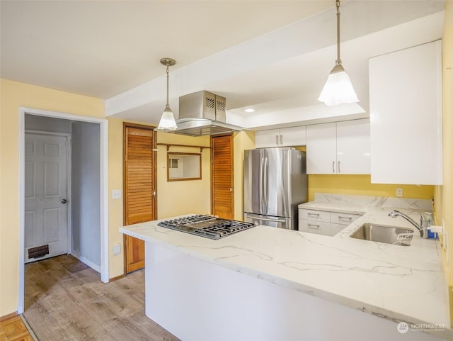 kitchen featuring sink, hanging light fixtures, light wood-type flooring, stainless steel appliances, and white cabinets