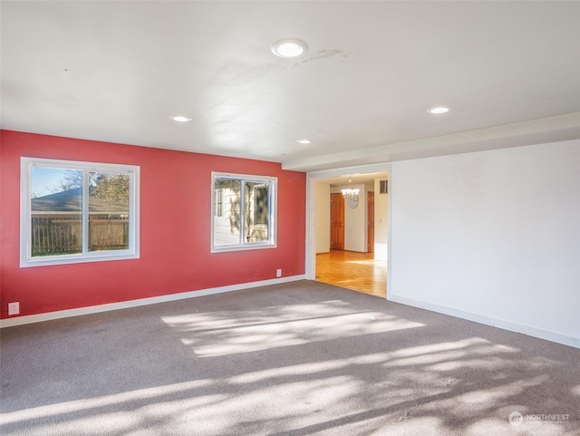 carpeted empty room with a notable chandelier