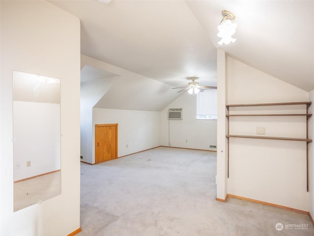 additional living space featuring ceiling fan, light colored carpet, vaulted ceiling, and an AC wall unit