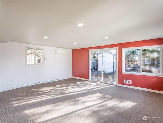 carpeted spare room featuring an AC wall unit