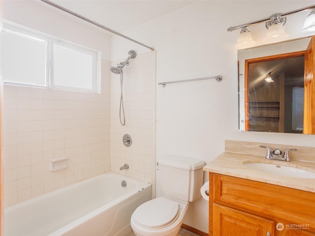 full bathroom featuring vanity, tiled shower / bath, and toilet