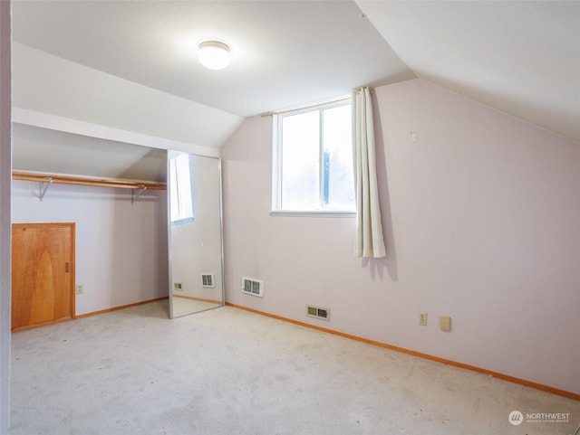 additional living space with vaulted ceiling and light colored carpet