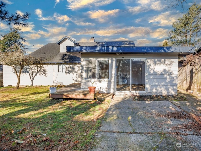 back of house featuring a wooden deck and a lawn