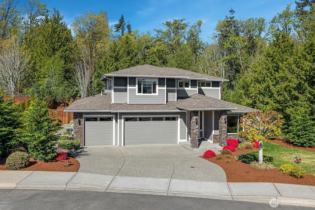 prairie-style house featuring an attached garage, stone siding, a shingled roof, and concrete driveway